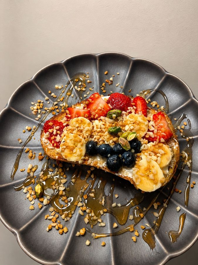 Tosta con queso crema, plátano, fresas, arándanos y granola